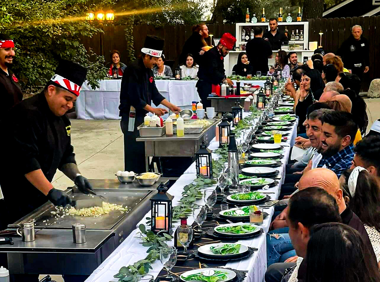 Guests toasting and smiling during a hibachi dinner show