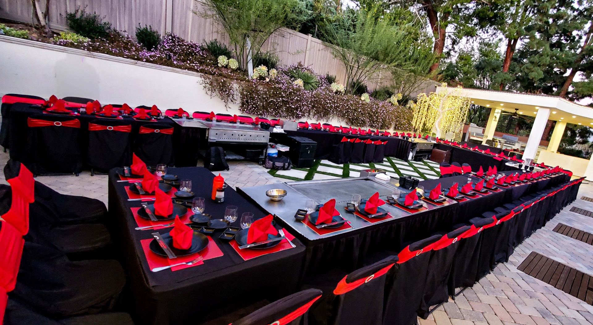 Chef setting up a black-and-red hibachi station